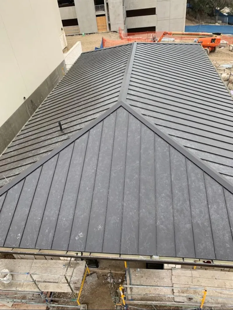 Commercial metal roof construction with crane equipment in Forest Glen
